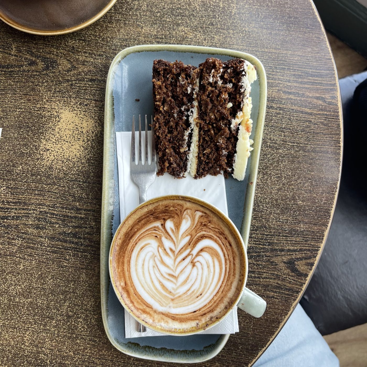 A slice of chocolate cake with a cappuccino