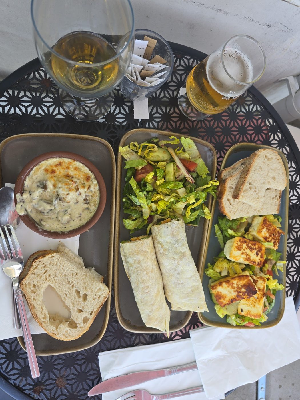 A sharing board with salad, wraps and bread
